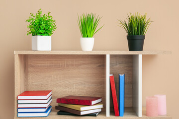 Fototapeta na wymiar Shelf unit with books and decor on color background