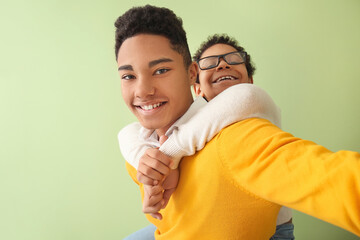 Obraz premium African-American boys taking selfie on color background