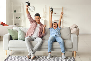 Cheerful African-American boys with game pads at home