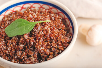 Bowl with tasty quinoa on table, closeup