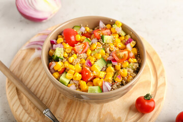 Bowl with tasty quinoa salad on light background