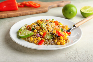 Plate with tasty quinoa salad on light background