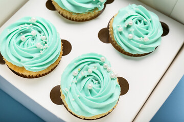 Box with tasty cupcakes, closeup
