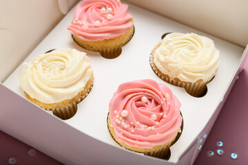 Box with tasty cupcakes, closeup