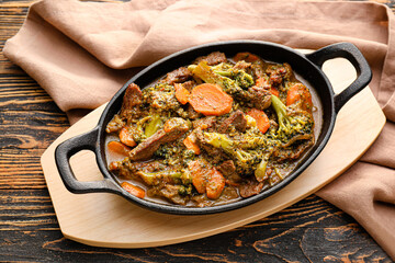 Tasty beef stroganoff with vegetables on wooden background