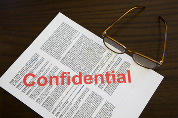 Confidential document with spectacles on desk
