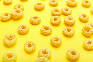 Tasty cereal rings on color background