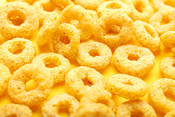 Tasty cereal rings on color background