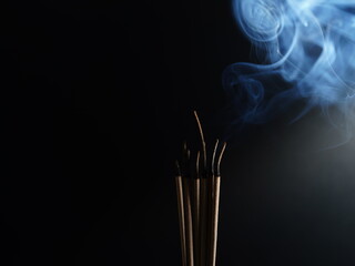 Burning incense white smoke black background used as a worship background image a sacred object of...