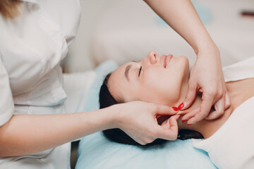 Obraz na płótnie Canvas young woman getting face treatment massage at beauty spa salon