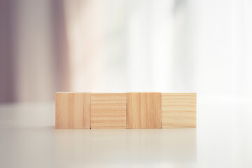 Four blank wooden block cubes on the table with blurred background for mockup, template, banner concepts