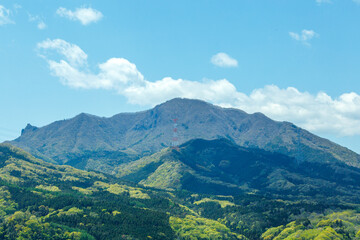新緑がきれいな山と霞んだ青空