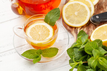 Herbal tea with mint and lemon. Tea cup and teapot
