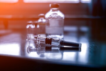 Vaccine vial dose flu shot drug needle syringe,medical concept vaccination hypodermic injection treatment disease care hospital prevention immunization illness disease  baby child.blue background 