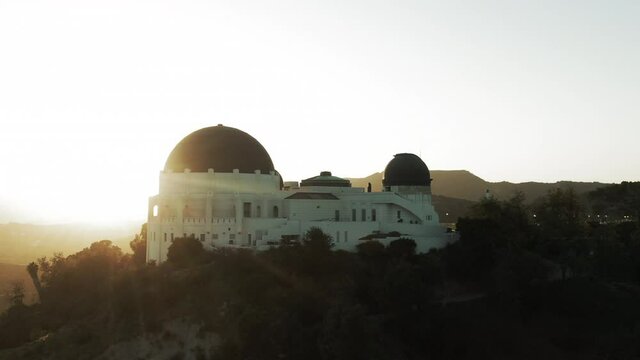 Aerial Shot Of Observatory On Mountain At Sunset, Drone Ascending Backward From Landmark Against Sky - Los Angeles, California