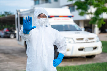 Driver wear PPE in front of the ambulance with protective suit at ambulance car vehicle for helping the patient of Coronavirus or Covid-19, Hand indication of stopping the spread of the coronavirus © tong2530