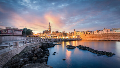Monopoli harbor in the Metropolitan City of Bari and region of Apulia (Puglia), Italy at sunset and...