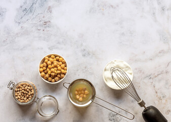Canned chickpea aquafaba. Egg replacement and substitutes. Vegan cooking concept. whipped foam in a...