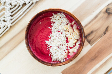 vegan smoothie bowl with raspberry vanilla oat milk smoothie topped with cocoa and coconut flakes, healthy plant-based food