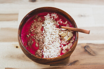 Obraz na płótnie Canvas vegan smoothie bowl with raspberry vanilla oat milk smoothie topped with cocoa and coconut flakes, healthy plant-based food
