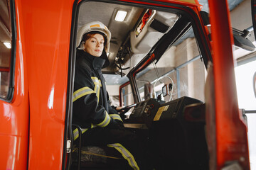 Naklejka premium Firefighters in a fire truck in uniform