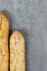 From above photo of french baguette bread on grey concrete background . Copyspace for text