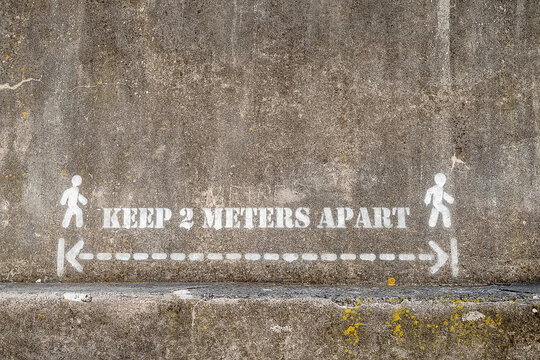 Keep 2 meters apart sign on a plastered wall. Health care recommendations during covid pandemic