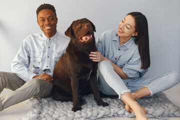 International couple on a blue background with a dog