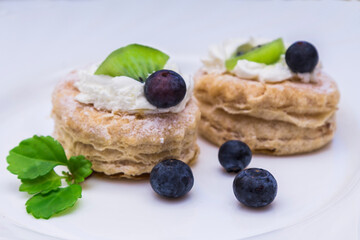 tasty mini puff pastry cakes with kiwi and blueberries