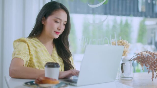 young attractive asian female wear casual cloth hand use smartphone and laptop device comminication social contact in cafe restaruant sit at counter next to big window daylight