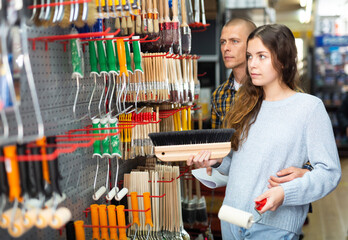Focused couple choosing supplies for home renovation in shop of building materials