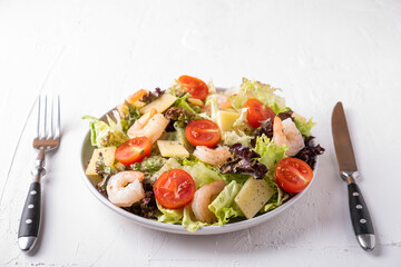 Shrimps,  cherry tomatoes, lettuce and cheese on a plate. Healthy and diet food concept