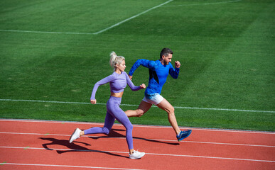 Fototapeta premium athletic woman and man of sprinters run on running track at stadium, endurance