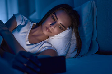 Young woman reading e book in bed