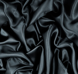 Smooth elegant black silk or satin texture as abstract background. Luxurious background design