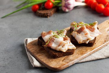 Two bread slices with salted pork bacon or lard, traditional snacks to Ukrainian borscht