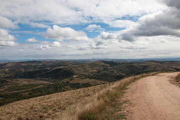 Curved Dirt Road on Hilltop Surrounded by Bleak Landscape