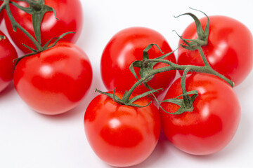 Tomatoes on a vine on a white background. Fresh and healthy vegetable. Ripe and juicy tomato