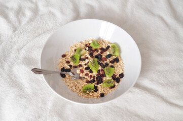 Oatmeal with raising and juicy kiwi fruits .Morning breakfast in bed 