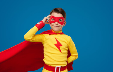 Smiling boy in superhero costume and mask