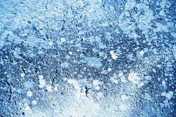 Paint splash on grunge wall. Graffiti texture. Spray paint splatter. Black paint blob pattern. Blue paint leak stains background.