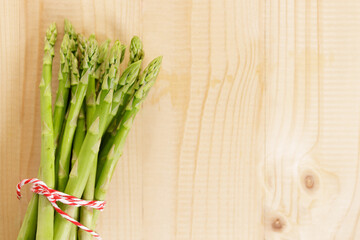 Fresh green asparagus on wooden table background.