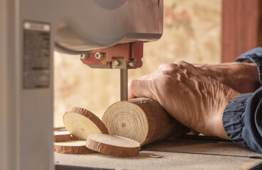 a man carpenter processes a wooden bar, cuts it into pieces using a special tool