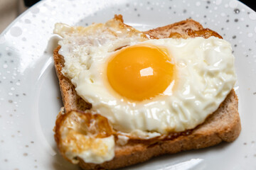 Toast sandwich with fried egg on a plate. Light, quick snack.