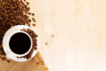 Cup of black coffee with coffee beans.