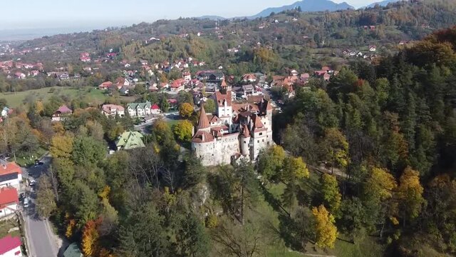 The famous medieval Bran Castle , the residence of count Dracula , situated on a hill in Bran County , Transylvania , Romania , aerial drone footage  , autumn season.