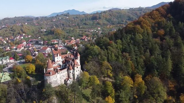 The famous medieval Bran Castle , the residence of count Dracula , situated on a hill in Bran County , Transylvania , Romania , aerial drone footage  , autumn season.