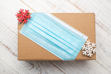 Gift and coronavirus concept. New Year's gift and medical mask on a white background.