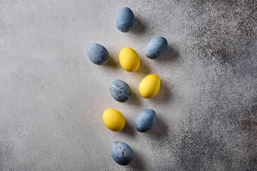 Fototapeta na wymiar Homemade Easter colored yellow and grey marble eggs on wooden background. Top view, copy space