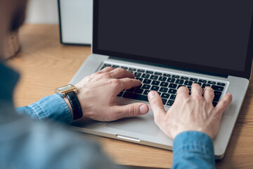 Fototapeta premium Close up picture of mans hands typing on a laptop
